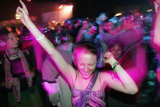 GLASTONBURY, ENGLAND - JUNE 25: A reveller enjoys the silent all-night disco in the Dance Tent on the second day of the Glastonbury Music Festival 2005 at Worthy Farm, Pilton on June 25, 2005 in Somerset, England. The headphones cost ?75, have two channels and over a 1000 were given out. The festival runs until June 26. (Photo by Matt Cardy/Getty Images) *** Local Caption ***