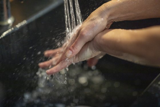 An adult washing her hands to prevent the spreading of Clovid-19.