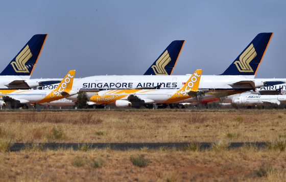 epa08634977 Airbus A320 airplanes of Singapore low-cost carrier Scoot Tigerair (front) and Airbus A380 aircrafts of Singapore Airlines, grounded due to the Coronavirus (COVID-19) pandemic, are parked at the Asia Pacific Aircraft Storage facility in Alice Springs, Australia, 30 August 2020. Aircrafts including the Airbus A380s and Boeing MAX 8s are being stored at the Alice Springs facility because central Australia's dry climate makes it a suitable place for long-term aircraft storage. EPA/DARREN ENGLAND AUSTRALIA AND NEW ZEALAND OUT