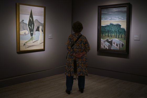 A visitor observes the works of the exhibition "The Magritte