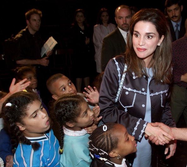 Children stand in line to meet Queen Rania, of Jor