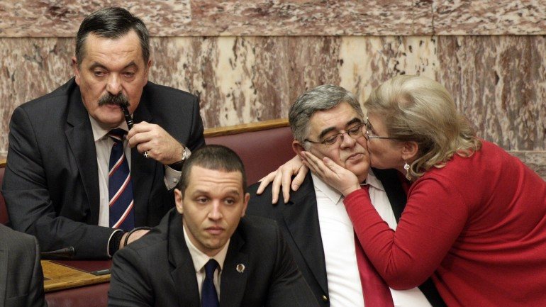 Michaloliakos, ainda no parlamento grego, a ser beijado pela mulher