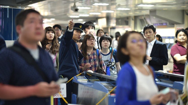Pessoas à espera que os comboios retomassem atividade, numa estação em Tóquio