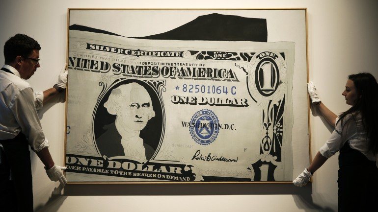 Colaboradores da Sotheby's transportam a pintura leiloada de Andy Warhol &quot;One Dollar Bill (Silver Certificate), 1962&quot;