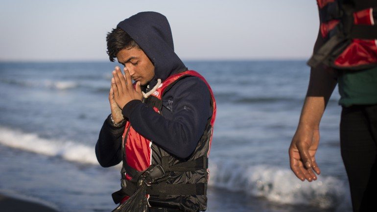 Refugiado sírio a rezar na chegada a Kos, na costa grega, este domingo