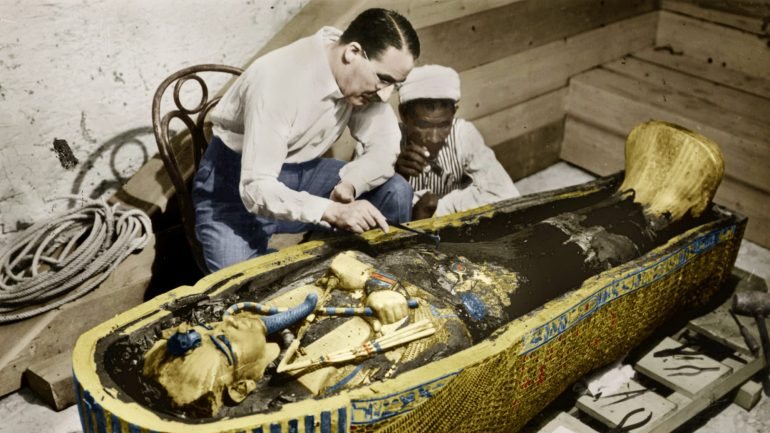O egiptólogo inglês Howard Carter junto ao sarcófago dourado de Tutankhamon no Egito, em 1923