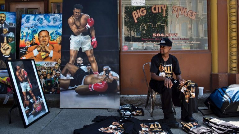 Um vendedor expõe memorabilia de Muhammad Ali no dia de funeral do campeão que se autointitulou &quot;O Maior&quot;
