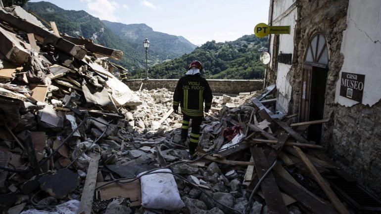 Um bombeiro entre os destroços causados pelo sismo