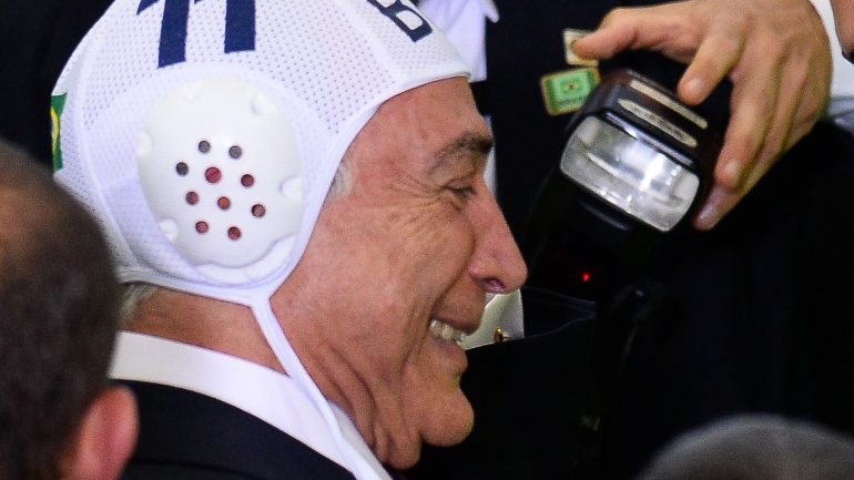 Michel Temer usou uma touca de polo aquático enquanto tirava fotos com atletas brasileiros, num evento oficial em Brasília.