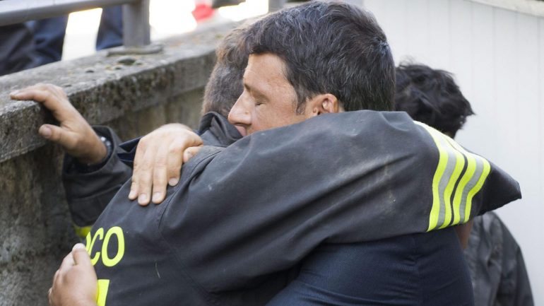 Matteo Renzi, primeiro-ministro italiano, abraça um socorrista após os terramotos dos últimos dias.