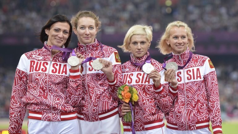 Antonina Krivoshapka, a terceira a contar da esquerda, acusou substância ilegal e a equipa vai perder a medalha de prata ganha