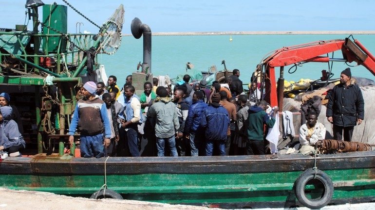 Migrantes resgatados ao largo da costa da Líbia por pescadores tunisinos de chegada ao porto de Zarzis