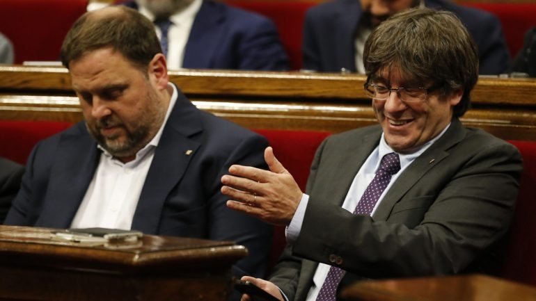 O vice-presidente do governo regional da Catalunha, Oriol Junqueras (à esquerda), sentado ao lado do presidente, Carles Puigdemont