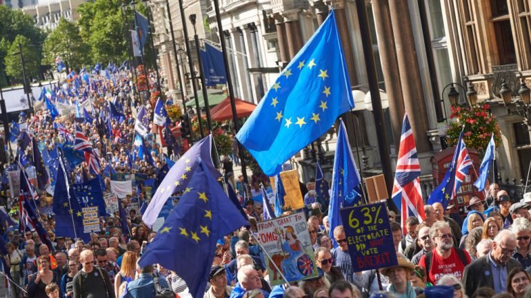 Alguns manifestantes empunham bandeiras da UE e outros exibiam cartazes com a inscrição &quot;Sair do 'Brexit&quot;