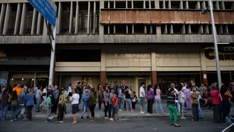 Pessoas aguardam no exterior dos edifícios evacuados em Caracas.
