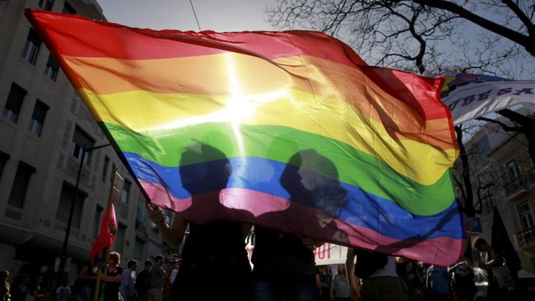 Dois participantes da 14.ª edição da Marcha do Orgulho Lésbico, Gay, Bissexual e Transgénero, seguram uma bandeira do Arco-Iris, simbolo gay, em Lisboa, 22 de junho de 2013. INACIO ROSA / LUSA