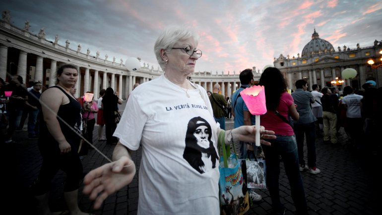 Uma mulher segura uma vela e veste uma tshirt com a cara de Emanuela Orlandi em 2013, para assinalar os 30 anos do desaparecimento da jovem de 15 anos