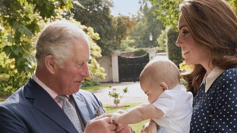 Príncipe Carlos a agarrar a mão do neto, Príncipe Louis, enquanto a duquesa de Cambridge o segura -- Foto tirada por: Chris Jackson/GETTY IMAGES