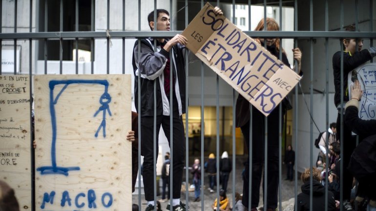Estudantes franceses colocam um cartaz nas grades que diz &quot;solidariedade com os estrangeiros&quot;