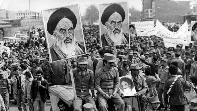 Soldados iranianos seguram imagens do ayatollah Khomeini em manifestação durante o período da revolução