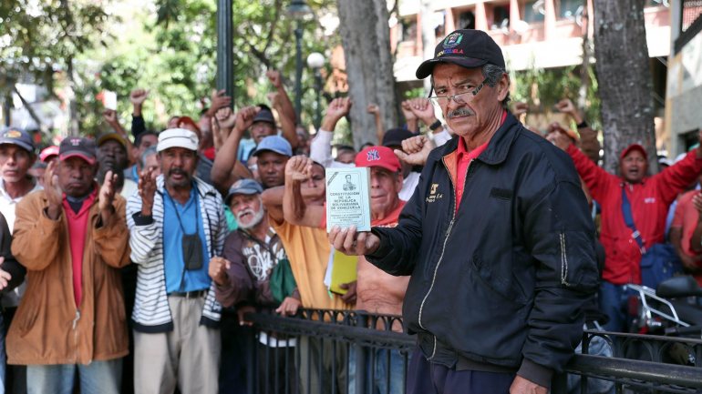Trabalhador de petrolífera mostra um exemplar da Constituição venezuelana durante um protesto