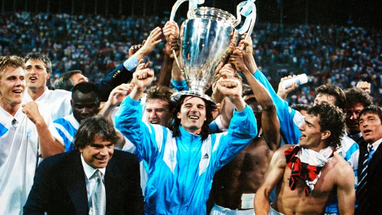 Éric Di Meco (com o troféu da Liga dos Campeões) era uma das estrelas do Marselha em 1993. Ao lado, de fato e gravata, Bernard Tapie
