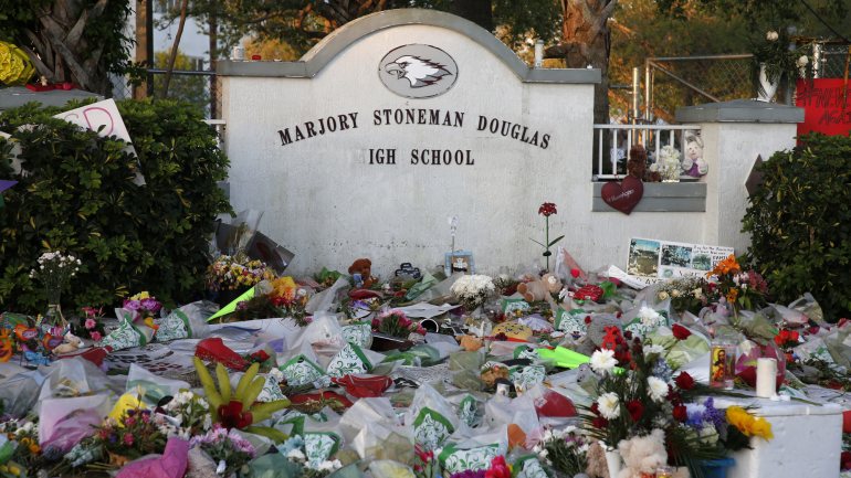 Símbolos de luto junto à escola de Stoneman Douglas, nos EUA, onde 15 alunos foram mortos num tiroteio