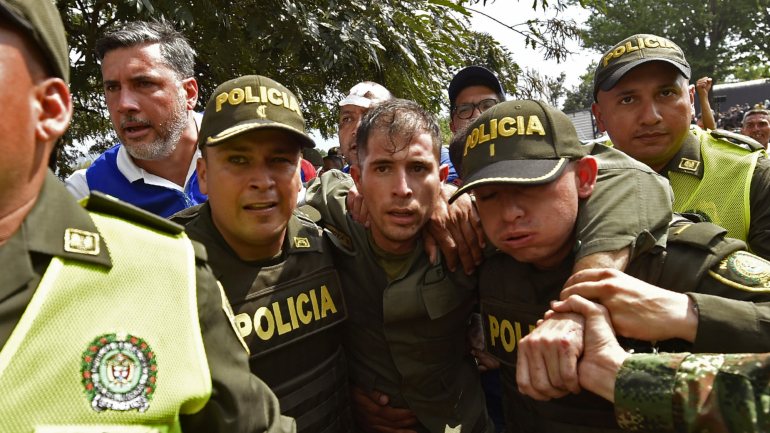 Polícias escoltam um dos desertores venezuelanos que atravessaram a fronteira para a Colômbia