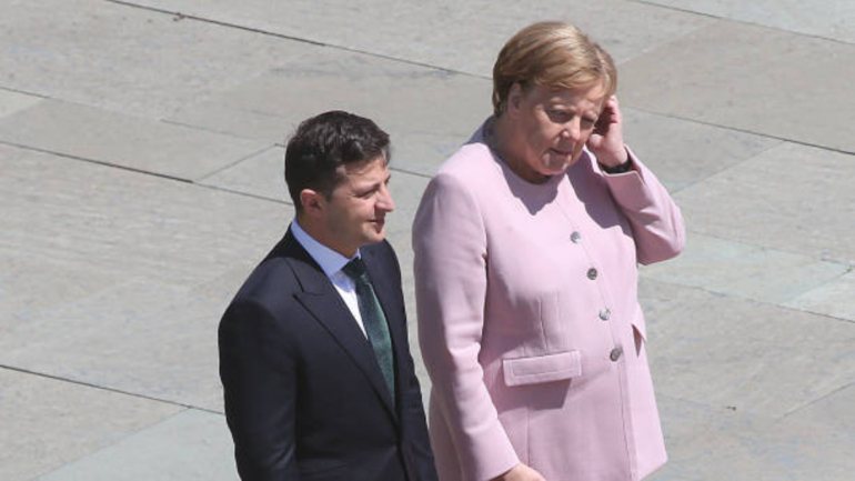 Angela Merkel não conseguiu conter os tremores enquanto uma banda do exército tocava os hinos da Alemanha e Ucrânia