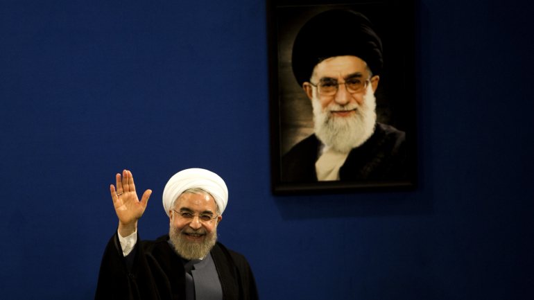 O presidente do Irão, Hassan Rouhani, junto a um retrato do ayatollah Ali Khamenei, líder do país
