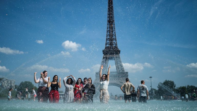 Em Paris, dezenas de turistas estão a usar a Fonte Trocadéro em frente à Torre Eiffel, como piscina