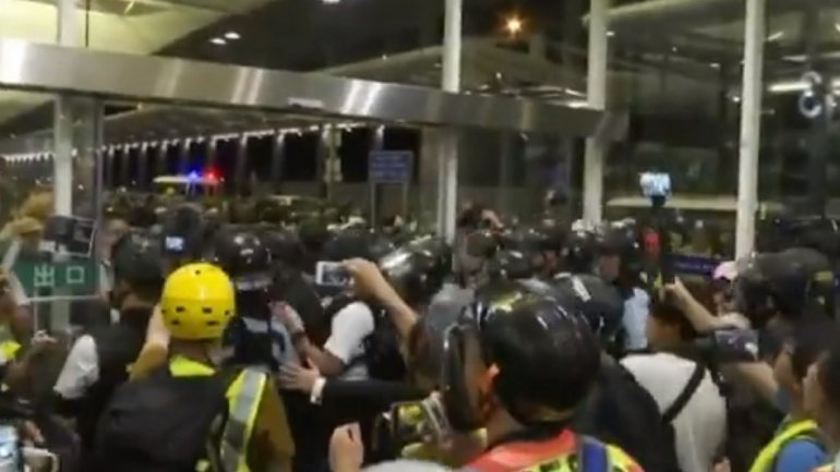 Vestidos de preto, a assinatura do movimento pró-democracia, os manifestantes gritavam: &quot;Levanta-te Hong Kong, levanta-te para a liberdade&quot;