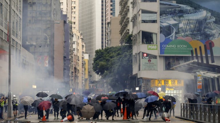 Os manifestantes, muitos deles usando máscaras, voltaram aos protestos, enfrentando a chuva, enquanto gritavam &quot;usar máscara não é crime&quot;