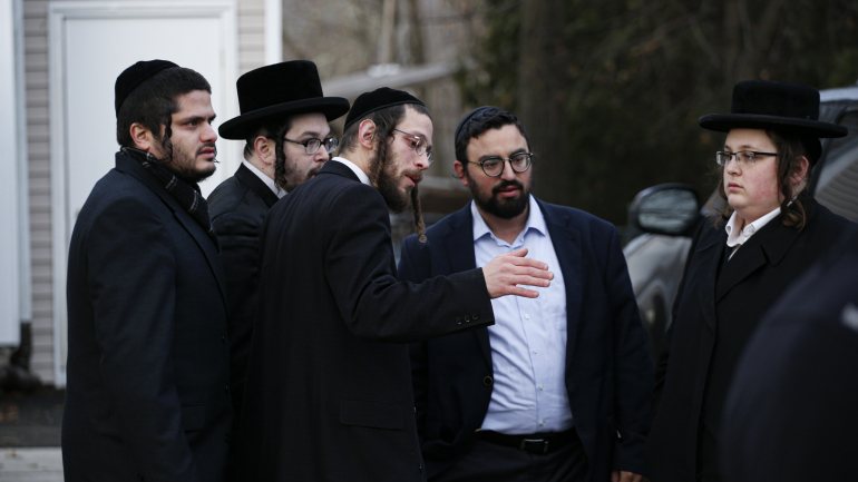 Membros da comunidade judaica de Monsey à porta da casa do rabino onde ocorreu o ataque no sábado à noite