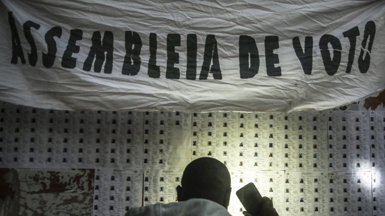 Um eleitor da Guiné-Bissau procura, com a ajuda de um telefone, o seu nome  nas listas eleitorais para as eleições presidenciais numa urna de voto em Bissau a 24 de novembro de 2019.