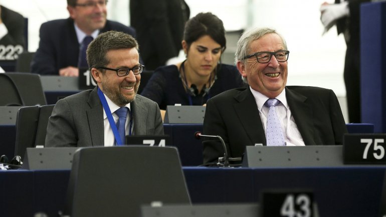 Carlos Moedas (à esquerda) elogia a &quot;arte&quot; de Jean-Claude Juncker (à direita), ex-presidente da Comissão Europeia, que evitou a aplicação de sanções da União Europeia a Portugal