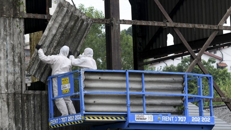 Dois técnicos removem placas de fibrocimento com amianto de fábrica desativada em Rio Tinto