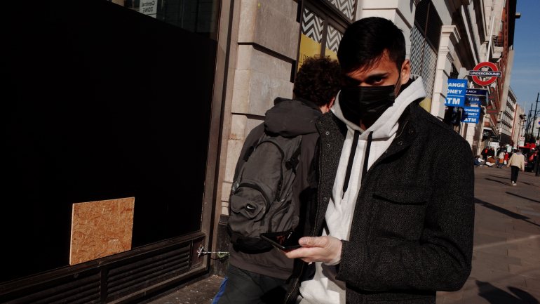 Um homem com máscara caminha em Marble Arch, Londres