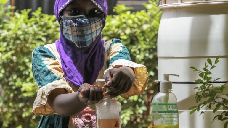 Mulher de máscara e a lavar as mãos no Burkina Faso
