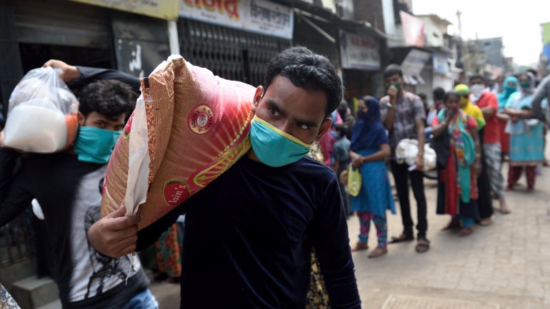 Fila de pessoas para recolherem mantimentos em Dharavi