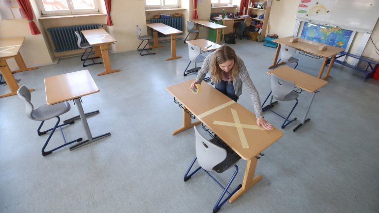 Aulas presenciais para alunos do secundário devem começar durante o mês de maio. Na Alemanha (foto), as mesas têm cruzes para marcar o distanciamento social
