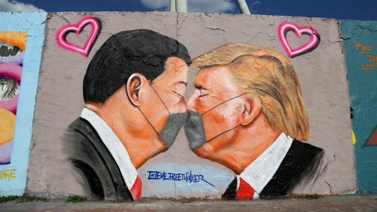 Mura em Berlim, com Xi Jinping e Donald Trump, ambos com máscaras, a darem um beijo