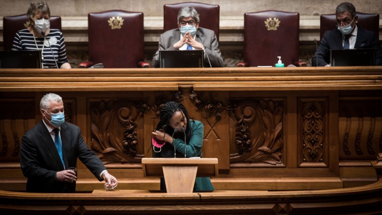 Joacine Katar-Moreira a tirar a máscara para falar no púlpito, a sua é reutilizável, um &quot;exemplo&quot; que queria ver o Parlamento dar.