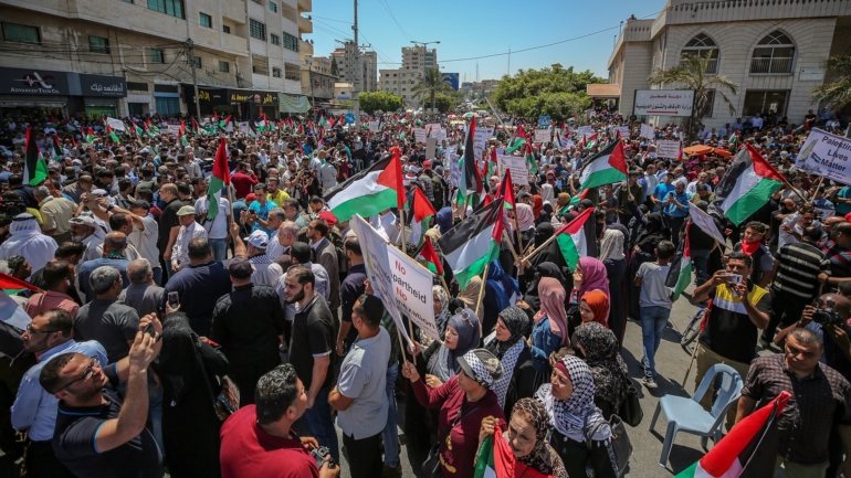 Os manifestantes ergueram bandeiras e cartazes em que se lia &quot;Não à anexação&quot; e &quot;Vidas palestinianas importam&quot;