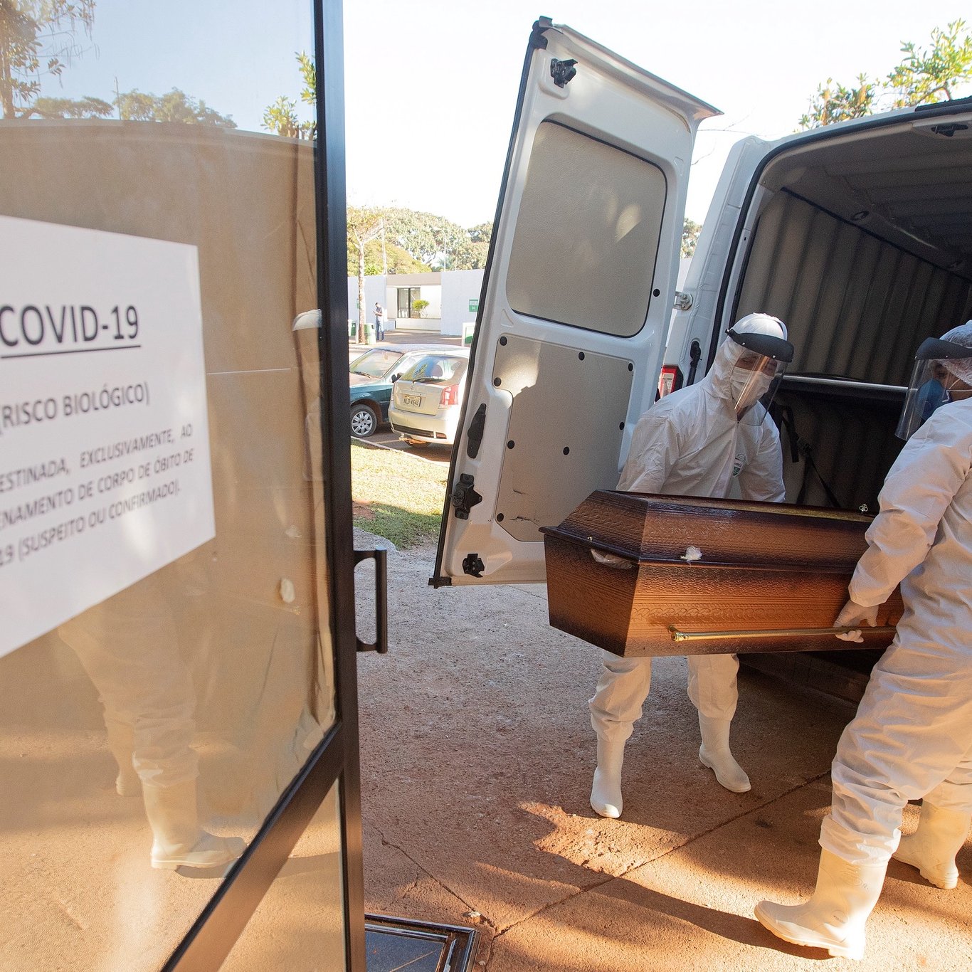 epa08477397 Funeral workers move caskets of coronavirus fatalities to a separate location, prior to burial at the Campo da EsperanÃ§a cemetery in Brasilia, Brazil, 10 June 2020.  EPA/Joedson Alves