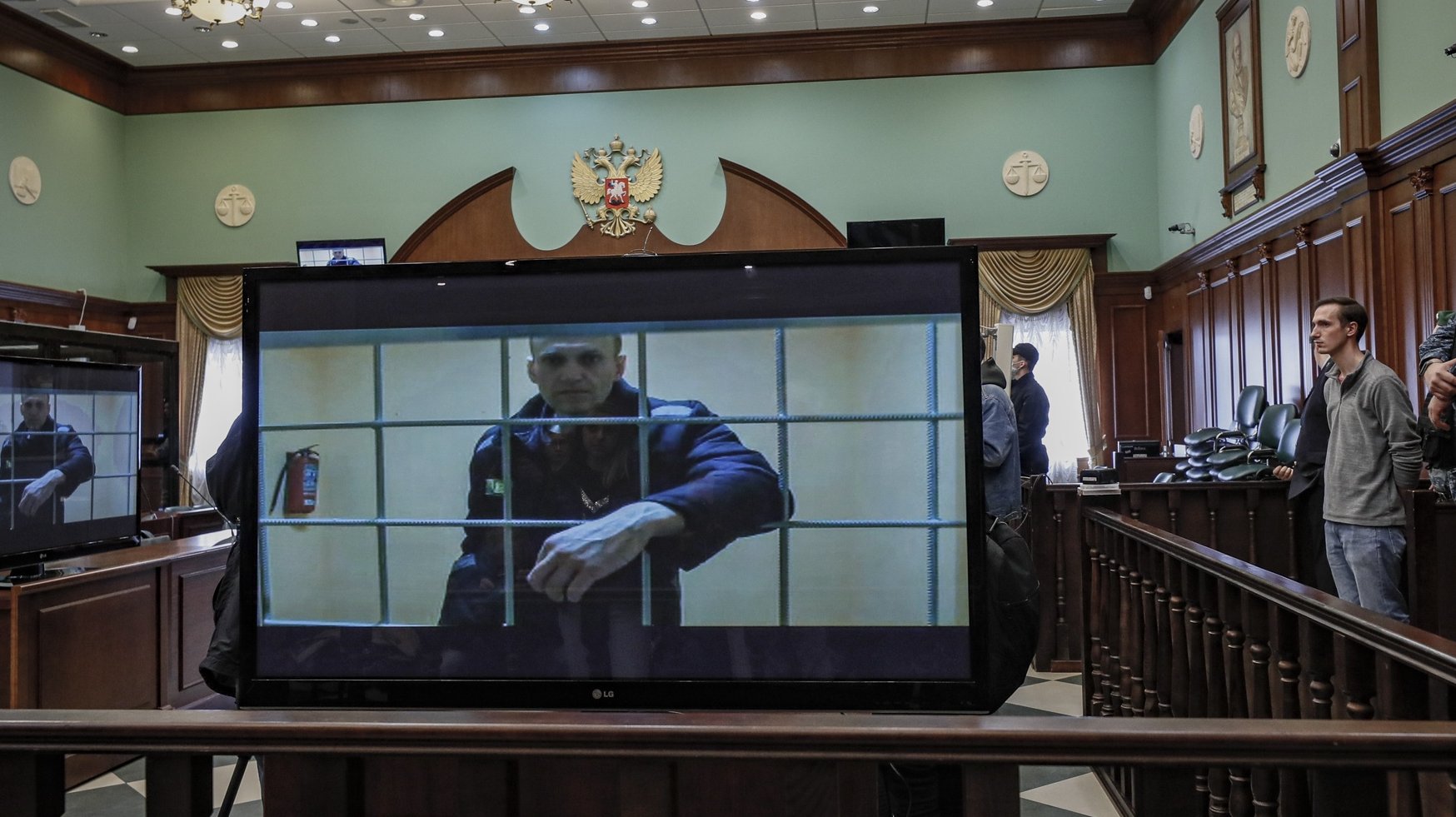 epa09971349 Russian opposition leader Alexei Navalny is shown on a monitor screen via video link from the penal colony No. 2 (IK-2) in Pokrov in Vladimir region, during a hearing of an appeal against Lefortovsky court sentence at the Moscow city court in Moscow, Russia, 24 May 2022. The Lefortovsky court sentenced politician Alexei Navalny to nine years in a strict regime colony and a fine of 1.2 million rubles for large-scale fraud and insulting the court. The Moscow city court upholded Navalny&#039;s conviction.  EPA/YURI KOCHETKOV