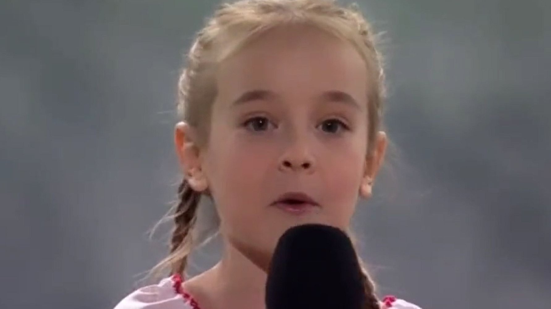 Amelia Anisovych canta o hino nacional da Ucrânia durante um concerto solidário na Polónia