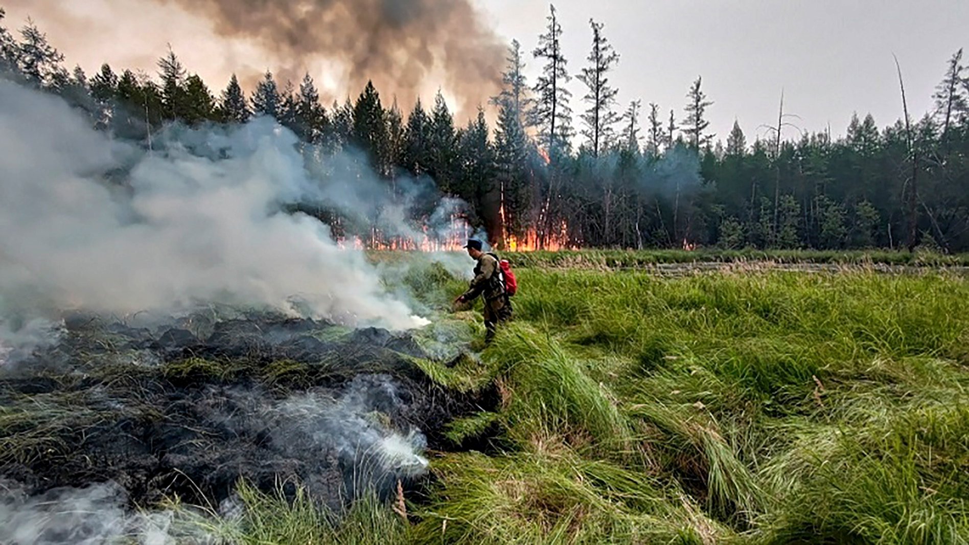 epa09392031 An undated handout photo made available by the Ministry of Nature Protection of Yakutia, shows a fire fighter extinguishing with the wildfire in the Republic of Sakha (Yakutia), Russia, issued 03 August 2021. According to the operational data of Russian Emergency ministry, 171 wildfires are active on the territory of the Republic of Sakha (Yakutia). 2423 people and 409 pieces of equipment were involved in extinguishing forest fires in Yakutia.  EPA/MINISTRY OF NATURE PROTECTION OF YAKUTIA HANDOUT  HANDOUT EDITORIAL USE ONLY/NO SALES
