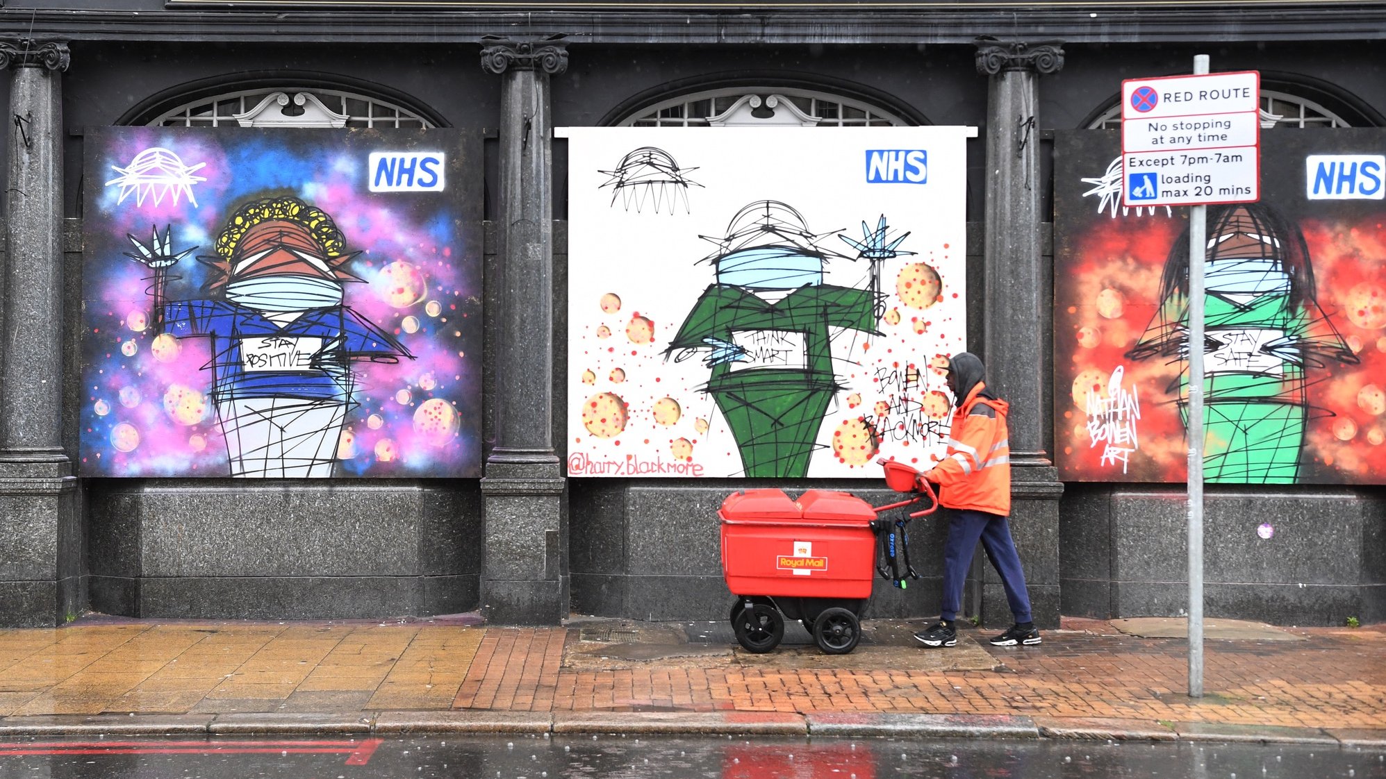 epa08389002 A Royal Mail worker walks past artwork in support of the NHS (National Health service) in London, Britain, 28 April 2020. A minute of silence was held nationally to mark the 84 health workers, including 69 NHS workers and 15 care workers who have had died due to the coronavirus.  EPA/FACUNDO ARRIZABALAGA
