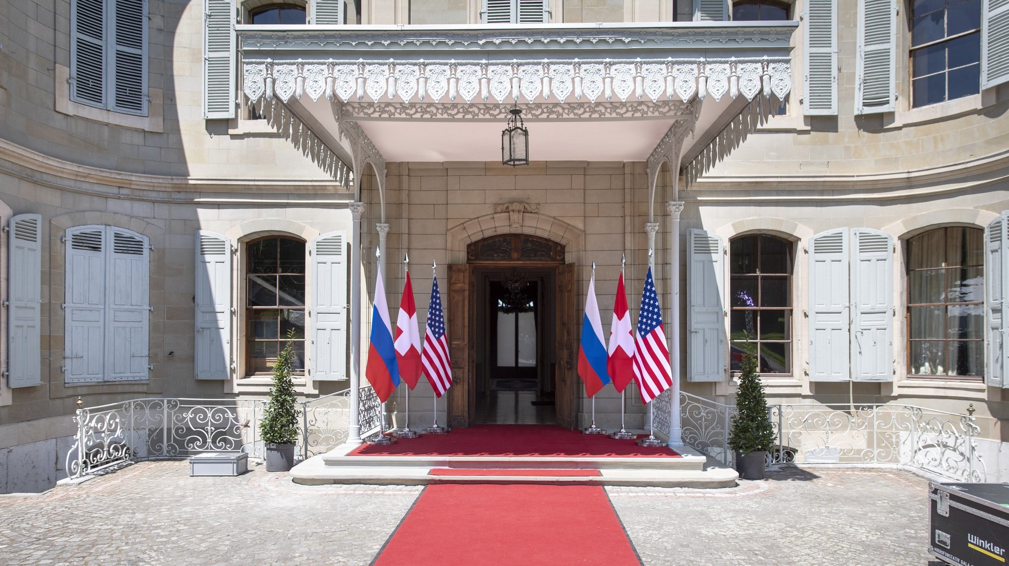 epa09273033 Flags of the US, Russia and Switzerland photographed in front of the entrance of the villa La Grange, one day prior to the US - Russia summit in Geneva, Switzerland, 15 June 2021. The meeting between US President Joe Biden and Russian President Vladimir Putin is scheduled in Geneva for 16 June 2021.  EPA/PETER KLAUNZER